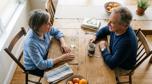 A couple in their sixties at a kitchen table with a glass of water