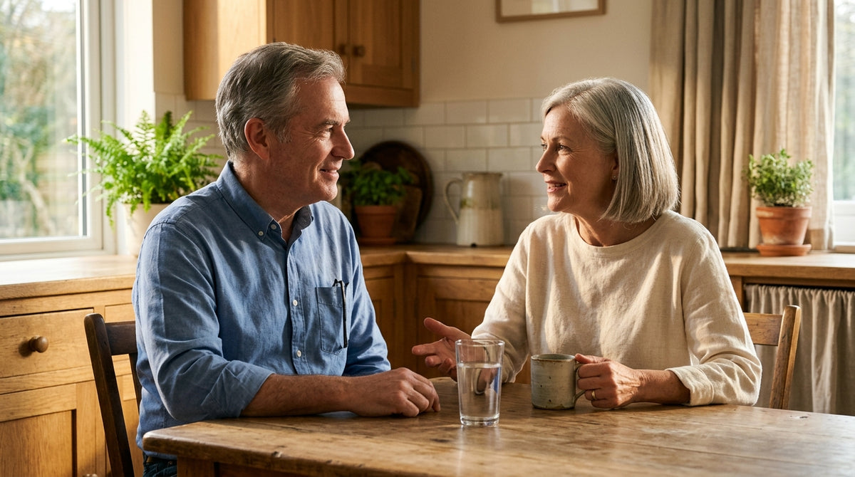 A couple in their sixties at a kitchen table with a glass of water