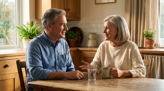 A couple in their sixties at a kitchen table with a glass of water
