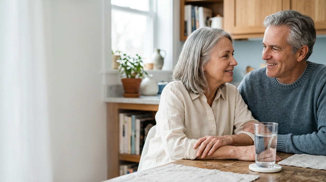 A couple in their sixties at a kitchen table with a glass of water
